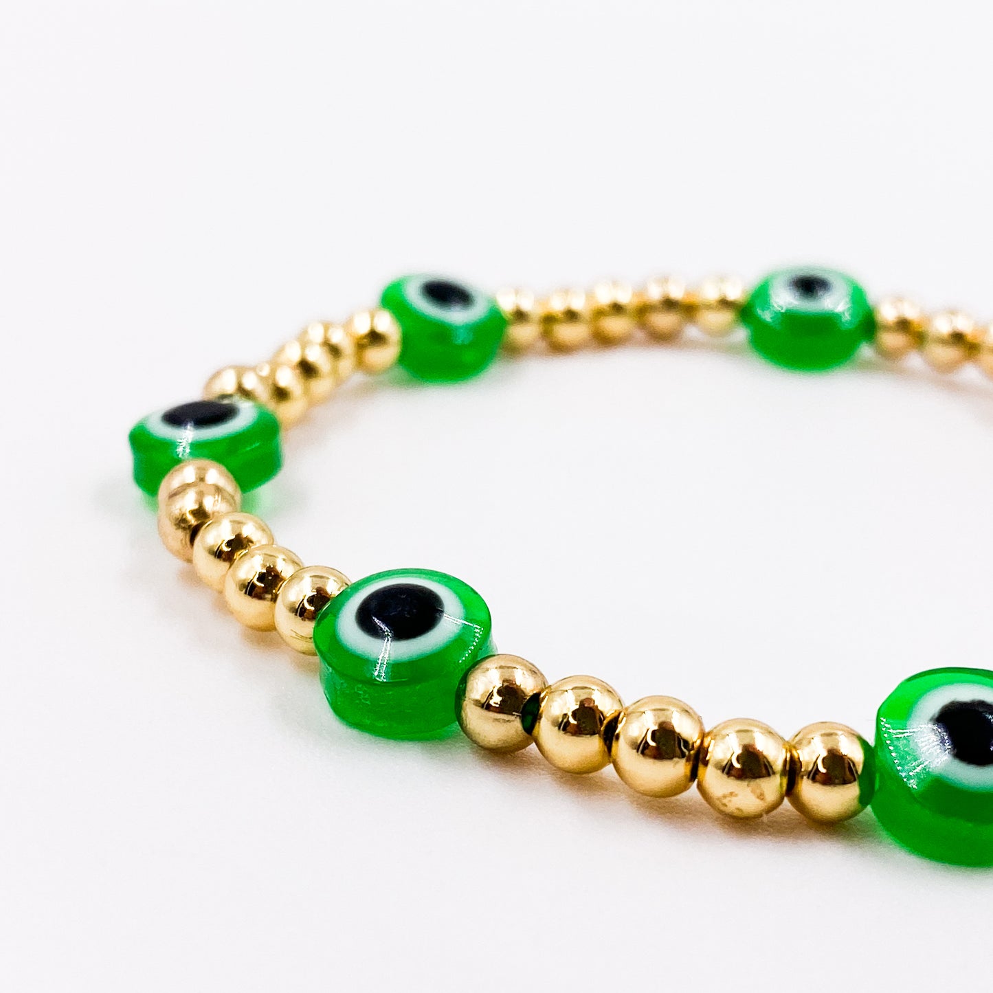 Pulsera con balines dorados pequeños y ojo turco verde